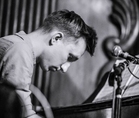 Black and white photo of Michael R. Oldham performing at a piano on stage