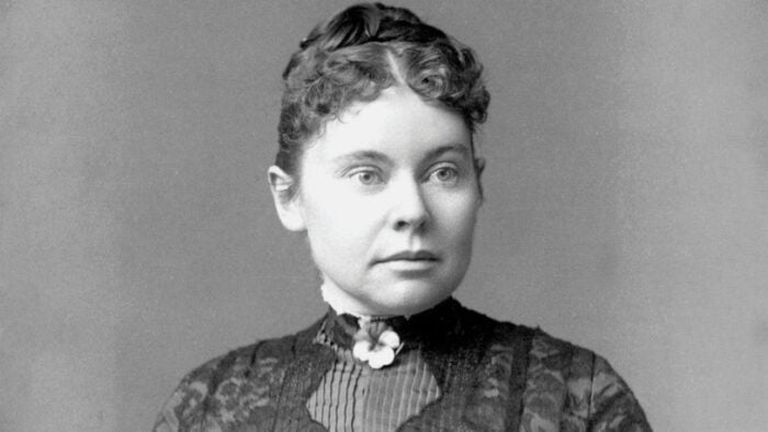 black and white photo of woman with tightly curled hair wearing a high collar