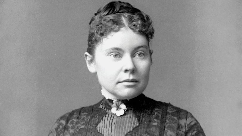 black and white photo of woman with tightly curled hair wearing a high collar
