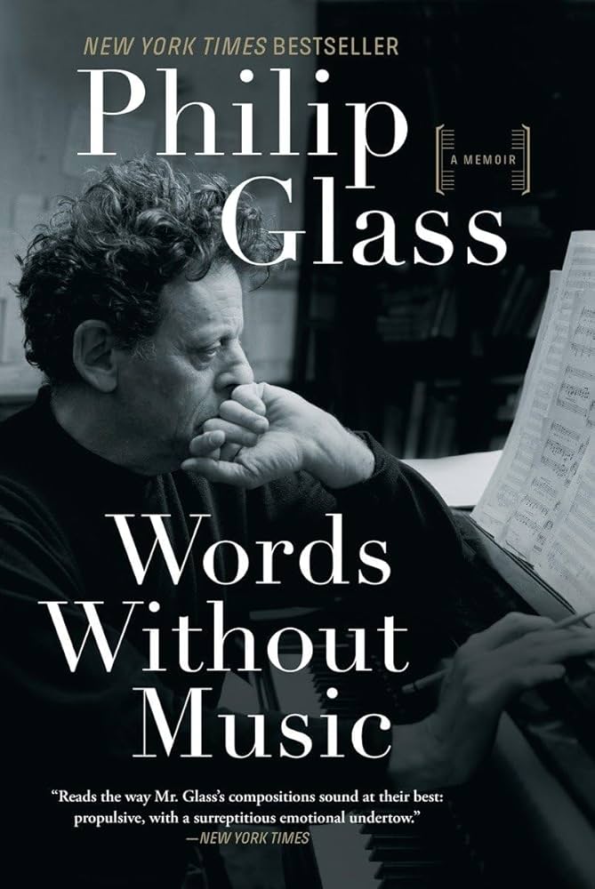 portrait of Philip Glass sitting at piano