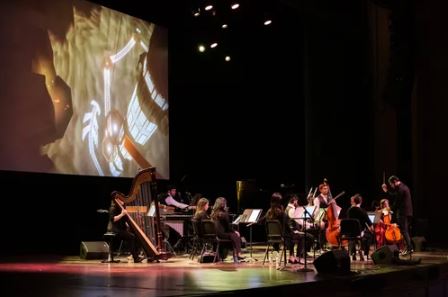 Members of Fifth House Ensemble performing on a dark stage