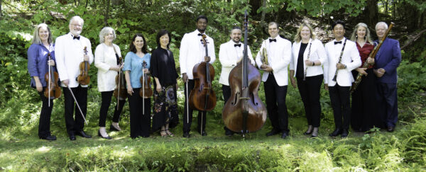 Members of Midsummer's Music pose in green outdoor area with their instruments