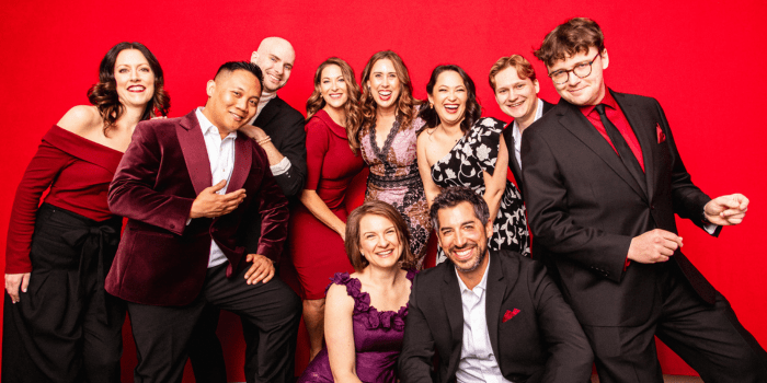 members of Chicago a cappella posing in front of a red background