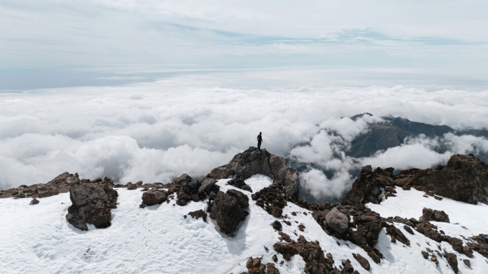 A man on a mountain above the clouds