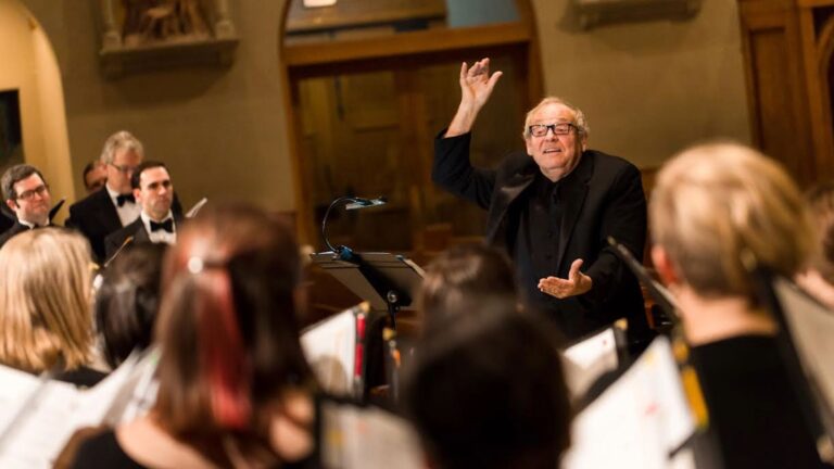 Performance image of Bruce Tammen conducting, perspective from within the choir.