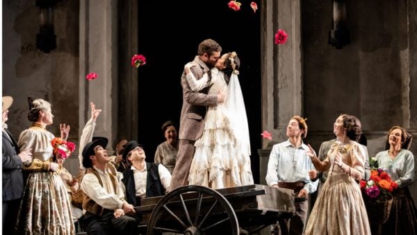 Lyric Opera's '26-27 Season: Don Giovanni, Omar, Guys & Dolls, and more A couple standing on a wheelbarrow kissing, woman in wedding dress, man in wool suit; working-class crowd watching and cheering.