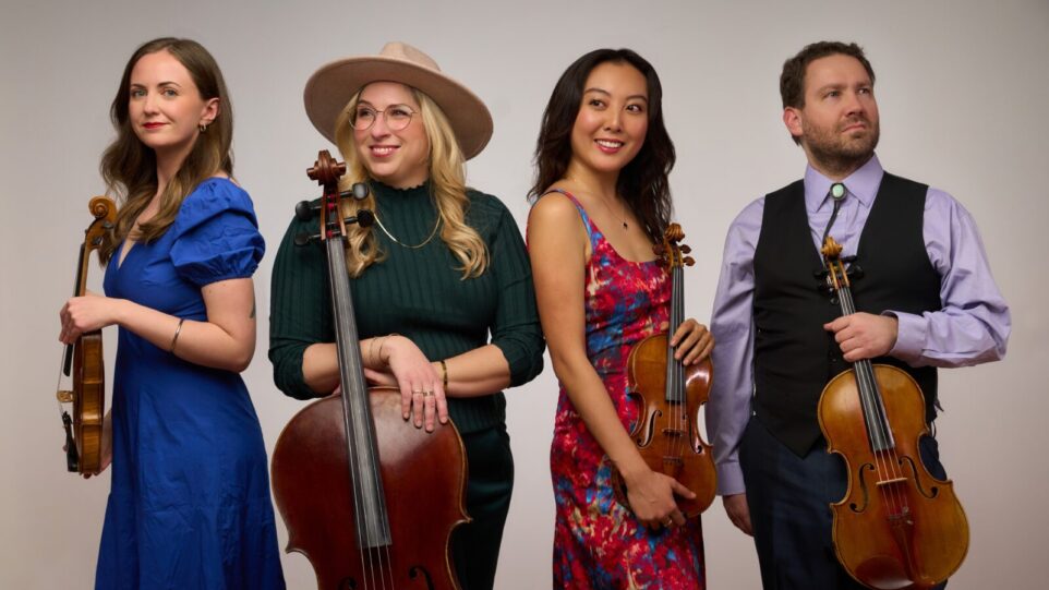 Members of the Kontras Quartet pose with instruments in front of grey background.