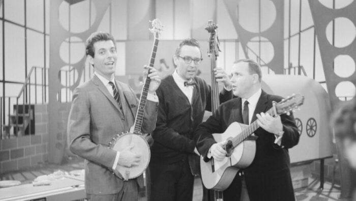 three men play banjo, bass and guitar and sing