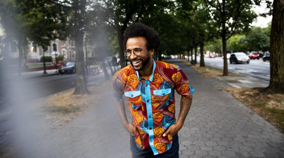 laughing man in African patterned shirt on a walkway in a park