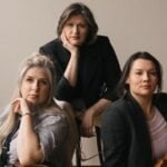 From left to right Jean Hatmaker with cello on her lap, Katherine Peterson, and Charlene Kluegel holding violin