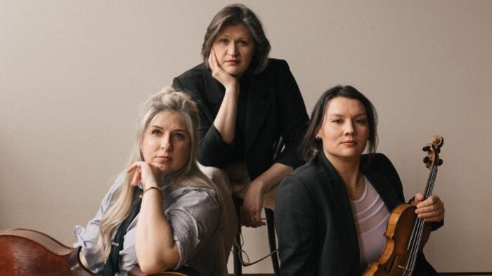 From left to right Jean Hatmaker with cello on her lap, Katherine Peterson, and Charlene Kluegel holding violin