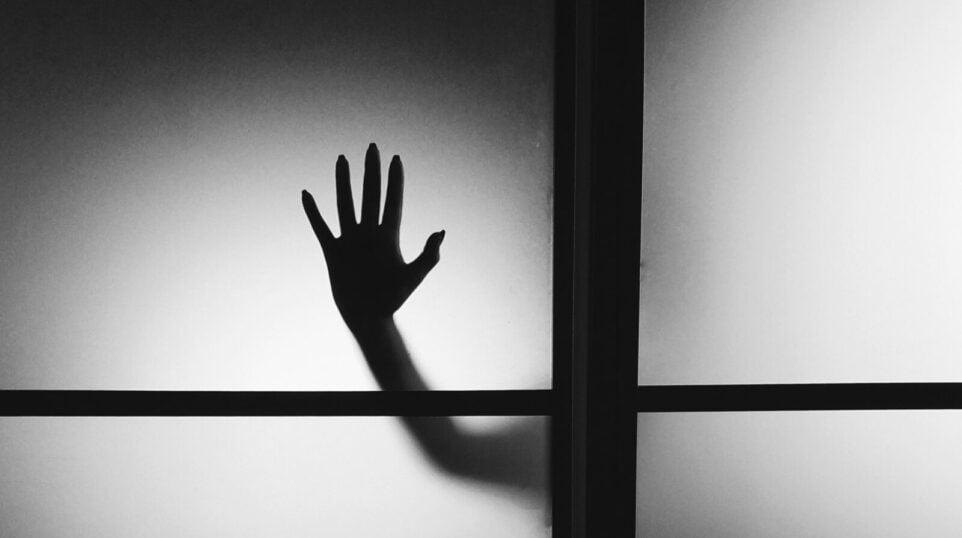 Black and White photo of a Hand outside a window