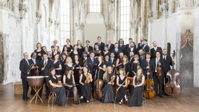 musicians with their instruments surrounding their conductor