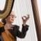woman playing harp in front of white background