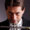 Man in suit holds trumpet and stares at camera