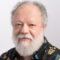 Man with white hair and beard and colorful shirt